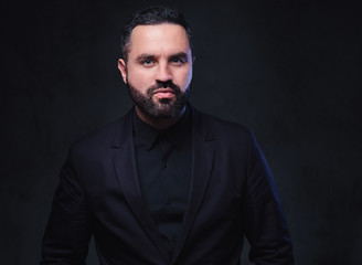 Bearded male dressed in a suit.
