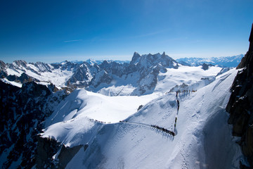 Aerial view of an expedition in the Alps covered in snow on a beautiful sunny day