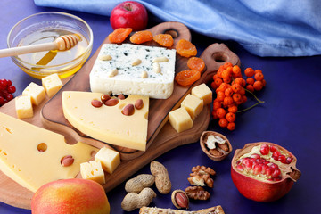 Various cheeses, apple, dried apricots, peanuts, walnuts, pears, berries, honey, jam, cheese with a mold on a wooden board in the style of pop art and retro style, Christmas cheese