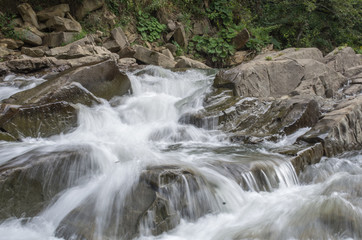 Water flowing by some rocks in a cascading stream in Bieszczady mountains