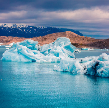 Floating of blue icebergs in Jokulsarlon glacial lagoon. Colorful sunset in Vatnajokull National Park, southeast Iceland, Europe. Artistic style post processed photo.