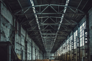 Abandoned large industrial warehouse hall with garbage. Demolished manufacturing factory, perspective 