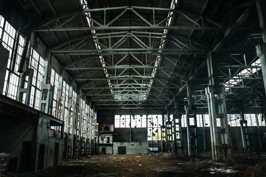 Abandoned large industrial hall or warehouse with garbage, manufactory factory