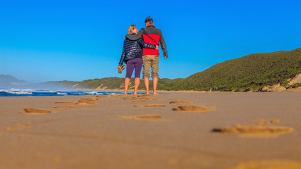 Aufnahme eines Pärchens während eines Strandspazierganges von hinten aus Bodenperspektive...