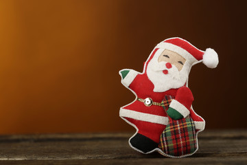 Simpatico Pupazzetto decorativo di babbo natale su sfondo arancione sopra superficie di legno
