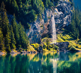 Sparkling waterfall on the Oeschinensee Lake. Splendid summer morning in the Swiss Alps, Kandersteg village location, Switzerland, Europe. Beauty of nature concept background..