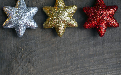 Christmas decoration.Silver,gold and red decorative christmas stars on old wooden background.Winter holidays,Merry Christmas,
Happy New Year concept.Copy space.
Selective focus.