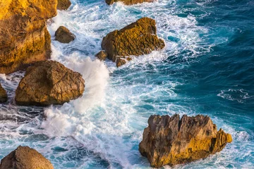 Wellen des Indischen Ozeans und das azurblaue Meer brechen an den Felsen der Insel und bilden einen weißen Schaum um die Steine. Fantastische malerische Landschaft von der Klippe Pura Uluwatu, Bali, Indonesien. © Valery Bocman
