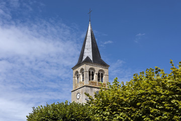 Fototapeta na wymiar France, Cormatin: Steeple with tower clock, green trees and blue sky
