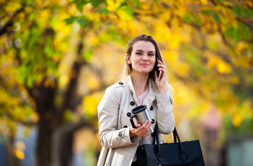 Beautiful woman talking smartphone walking colorful autumn street