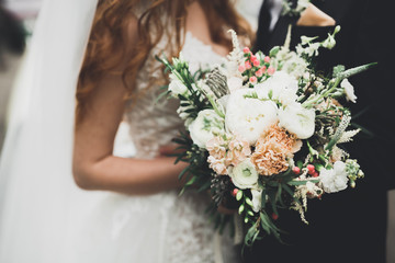 Luxury wedding bouquet in bride's and groom hands