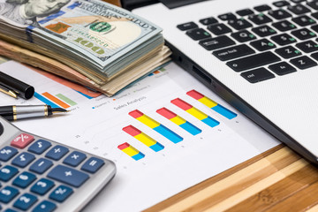 dollar with business graph and laptop