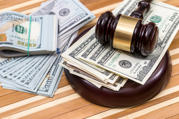 wooden gavel with dollar banknote on desk