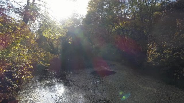 Aerial view over an Off-road vehicle crossing a river in speed.