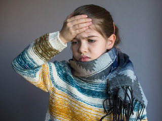 A little girl has flu, her head  hurts