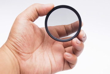 Hand Holding Camera Lens Filter Over White Background