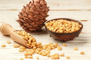 Cedar (Pine) nuts and cones on white wooden table. Selective focus