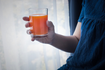  Female hand holding cup of orange juice in morning when she wake up.healthy  lifestyle concept