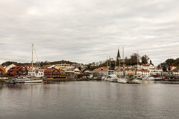 Fototapeta na wymiar Grimstad, Norway - October 31 2017: Grimstad harbor and city seen from a distance, Norway, Europe. Panorama
