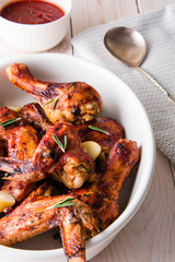 Fried chicken legs and wings with rosemary and garlic on white background, closeup.