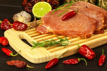 Sliced spicy pork on a bamboo cutting board. Sale of meat in butcher.