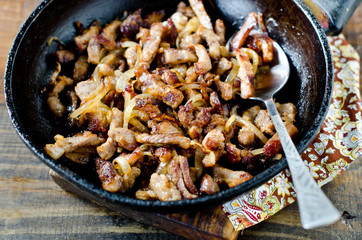 Meat fried with onions in a frying pan