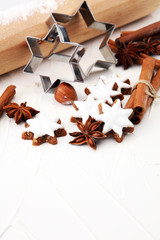 Christmas baking ingredients and tolls for dough preparation. Flour, rolling pin and cookies and spices.