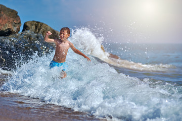 Fototapeta premium Cute Caucasian boy in sea waves.