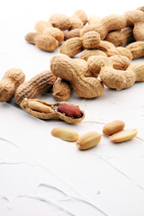 Peanuts in nutshell on white background and peeled peanuts.