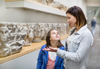 Mother and daughter exploring bas-reliefs in museum