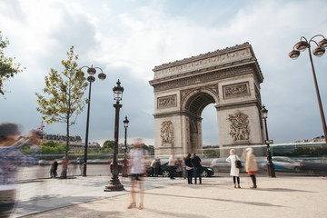 Obraz premium Famous Triumphal Arch, symbol of the glory and historical heritage. Iconic architectural landmark of Paris, France. Charles de Gaulle square. City life, tourism and travel concept. Long exposure.