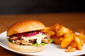 Pulled pork burger with cole slaw and country potatoes, wedges and ketchup, close up