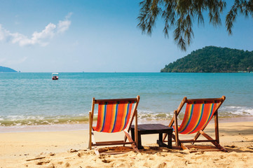 Two beach chairs on idyllic tropical beach.