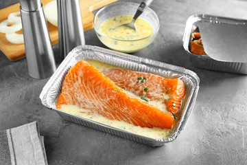 Dish with salmon fillet in lemon mustard marinade on table