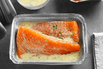 Dish with salmon fillet in lemon mustard marinade on table
