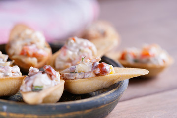Tartlets with spicy salad on a wooden background 