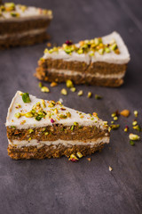 Paleo raw vegan pistachio carrot cake with cashew cream layers. Dark food photography concept