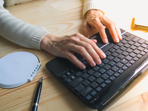 Close-up of female hands using laptop computer. Searching Internet, social networking concepts.

