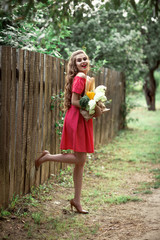 beautiful caucasian girl in red dress holding a bag of food