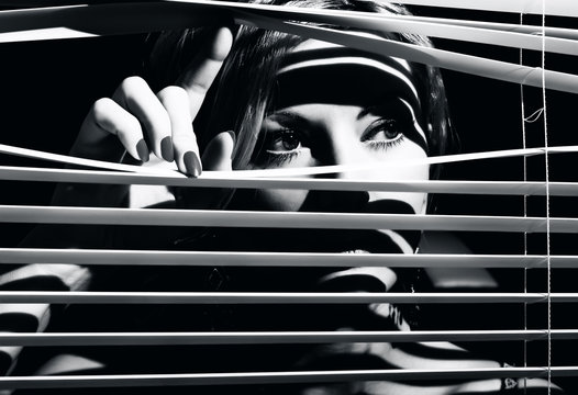 Closeup shot of sexy young woman looks through the jalousie - Powered by Adobe