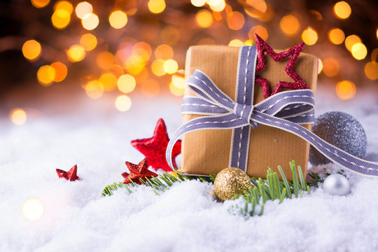 Christmas gift in snow landscape with bokeh background