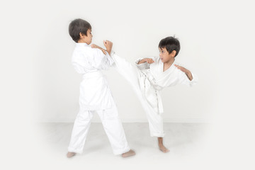 two boys of the karateka in a white kimono battle or train