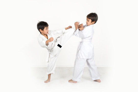 two boys of the karateka in a white kimono battle or train