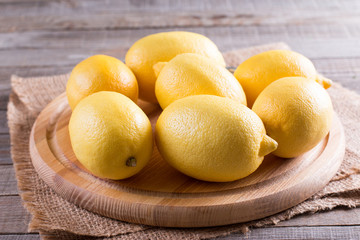 Fresh juicy lemons on a cutting board on a rustic wooden background