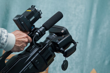 Video camera operator working with his equipment Video camera taking live video streaming at people working background