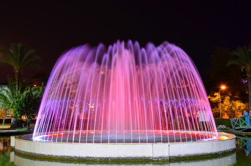A LED lighted fountain in Kugulu Park near Grand Haber Hotel and Mediterranean Sea shore. Long exposure night photo.