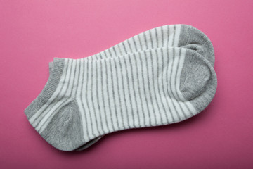 Gray female socks in stripes on a pink background.