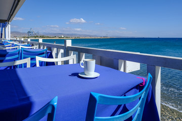 Having coffee on a blue table beside the sea in Limassol, Cyprus