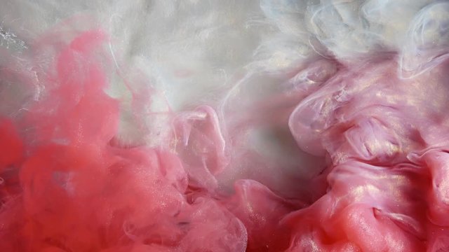 Colorful red/white paint drops from above mixing in water. Ink swirling underwater. Cloud of ink isolated. Colored abstract smoke explosion animation. Close up view