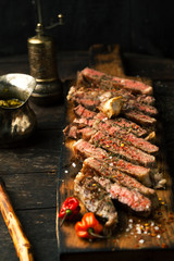 Sliced medium rare grilled steak ribeye with salt, spices, and rosemary